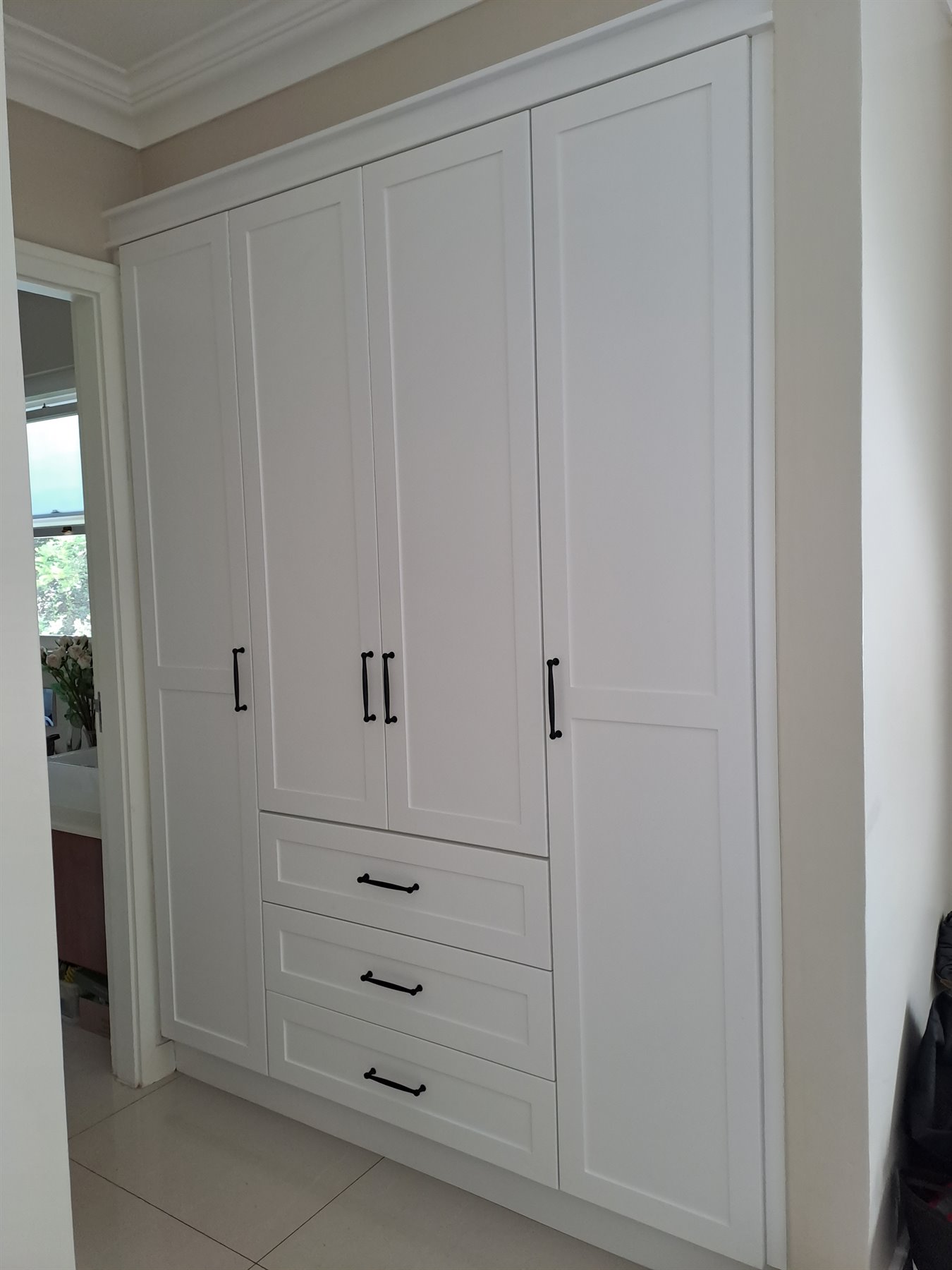 White bedroom cupboards with overhead storage