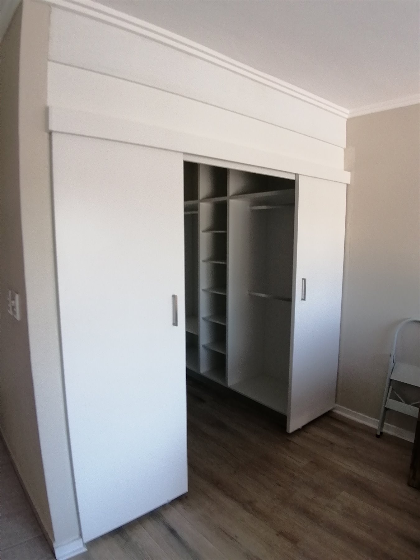 White sliding-door walk-in wardrobe